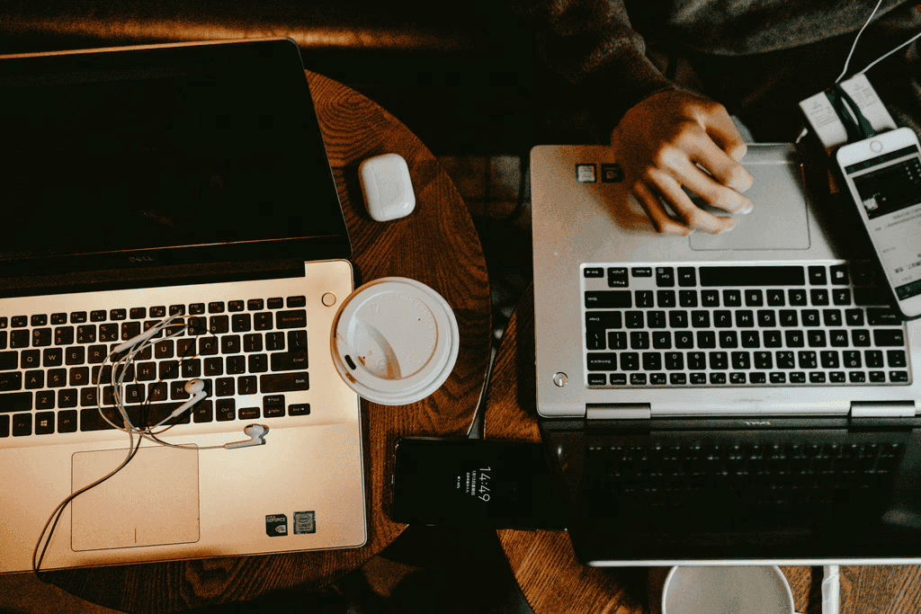 A person working on the laptop while another works with papers.