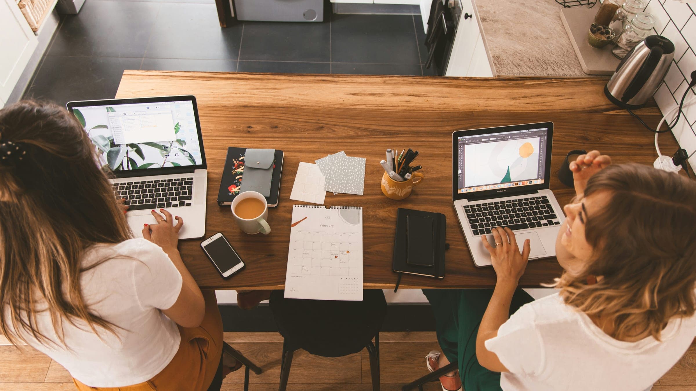People working at a table with laptops and papers.